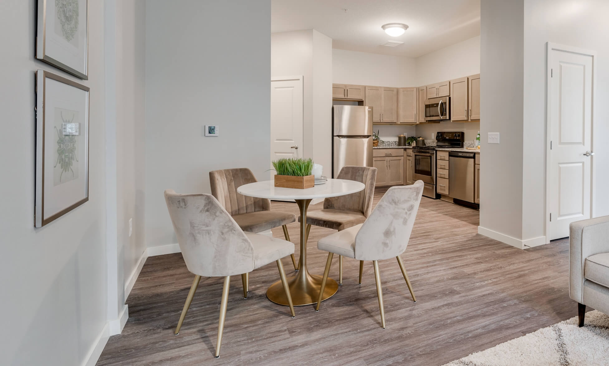 Dining area with round table and kitchen in the background.